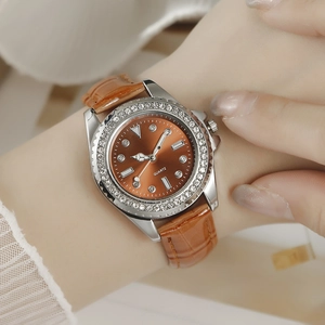 Close-up of luxury women's watch with caramel brown dial and shimmering rhinestone bezel