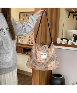 Detail of bohemian patchwork tote bag featuring floral patterns and a SEEYOU cloth label