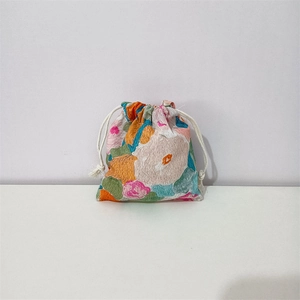 Detail of floral cotton drawstring pouch showing fabric texture and colorful patterns