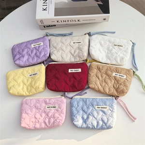 Flat lay of colorful quilted heart-pattern mini coin purses in eight pastel colors