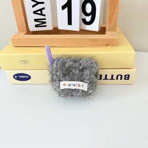Detail of plush gray wireless earphone case with purple charm and mayrabbit logo