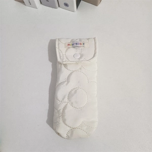 Detailed view of quilted flower texture on cream fabric glasses case with snap button