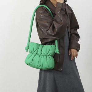 Primer plano del bolso nube verde brillante acolchado con nudos y textura plisada