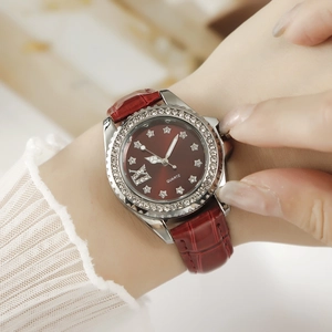 Gros plan d'une montre à quartz pour femme avec bracelet en cuir bordeaux et strass