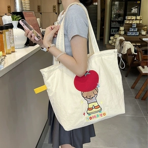Gros plan détaillé du sac cabas blanc avec motif brodé d'ours et de tomate