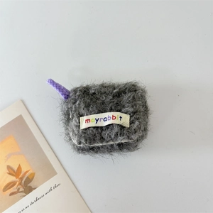 Close-up of grey plush earphone case with purple braided lanyard and lettered label