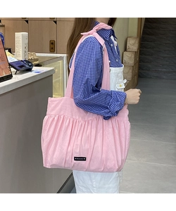 Detailed shot of pink pleated cotton linen tote bag featuring a decorative bow on the strap