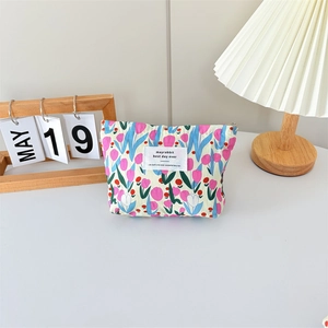 Close-up of floral canvas makeup bag with tulip prints on a cozy bedside table