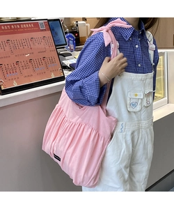 Detail of pink ruffled tote bag made of soft pleated cotton fabric with wide shoulder strap