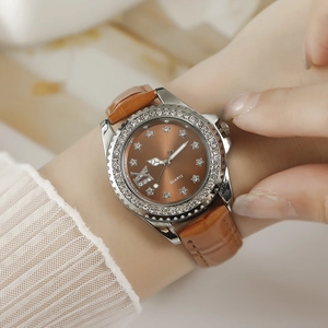 Détail d'une montre femme élégante avec cadran à étoiles et lunette en strass