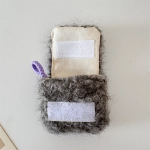 Detail view of plush earbud case with dark grey faux fur and velcro closure