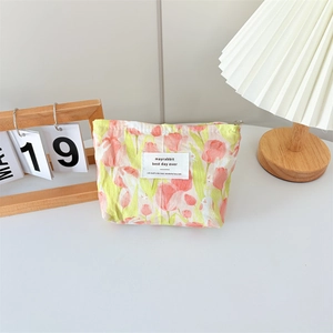 Detailed macro shot of canvas makeup bag with tulip pattern and branded woven label