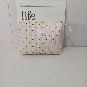 Detailed macro of the soft quilted fabric texture with heart prints on cream bag