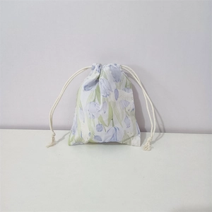 Detail view of cotton drawstring pouch featuring purple tulip patterns on white background