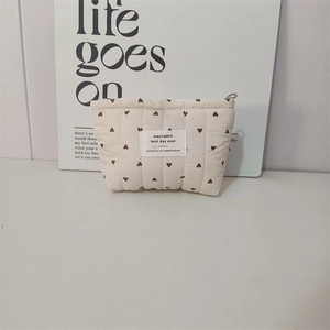 Detail of quilted cotton makeup bag with heart pattern and secure zipper closure