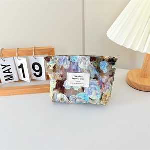 Detail of floral canvas makeup bag with zipper closure on a stylish desk setup