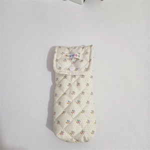 Close-up of quilted floral fabric case with snap button and diamond stitching pattern