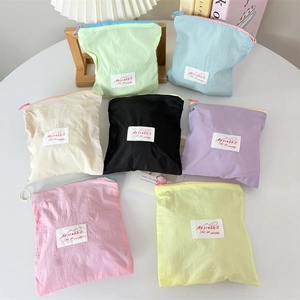 Mini macaron nylon makeup pouches in seven colors on a white table for small jewelry