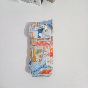 Detailed view of quilted fabric glasses case with blue cartoon street illustration and button
