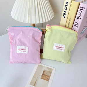 Macro shot of macaron-colored mini jewelry pouches with zipper detail and soft fabric texture