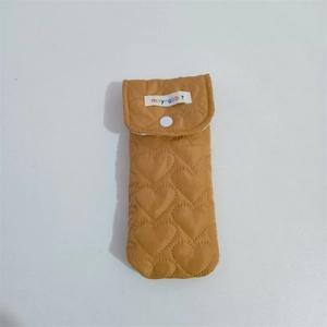 Detail of yellow heart-quilted glasses pouch with resin snap button and fabric label