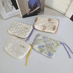 Détails de quatre pochettes en coton matelassé aux motifs de fleurs et d'oursons