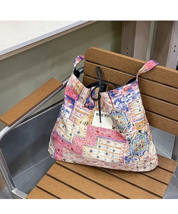 Detailed view of colorful ethnic patchwork tote bag resting on a wooden vintage chair