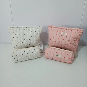 Quilted heart pattern cosmetic bags set with zipper closure and logo tag details