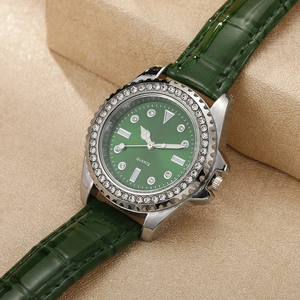 Detail of luxury women's quartz watch with green sunray dial and rhinestone bezel