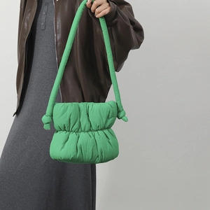 Detalle del bolso de nube acolchado verde vibrante con correa de hombro anudada