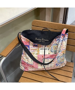 Close-up of vintage patchwork floral patterns and brand label on a denim tote bag