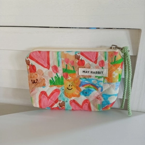 Détail de la pochette matelassée en coton avec motif ours et tirette tressée verte