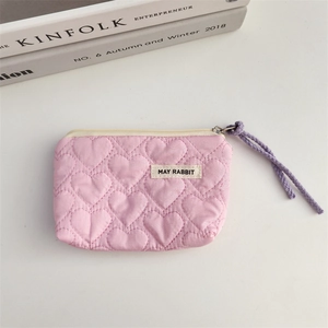Detail of pink quilted heart pouch with a cream zipper and May Rabbit brand label