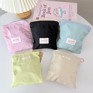 Detailed top view of colorful nylon cosmetic bags in pastel pink blue and green tones