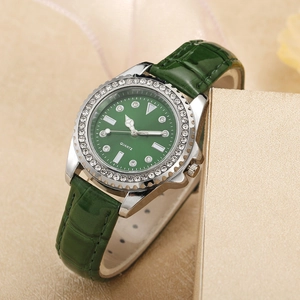 Detail of green quartz watch with rhinestone bezel and crocodile pattern leather strap