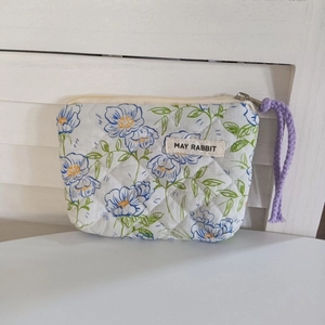 Détail du mini sac matelassé fleuri avec étiquette MAY RABBIT et cordon mauve