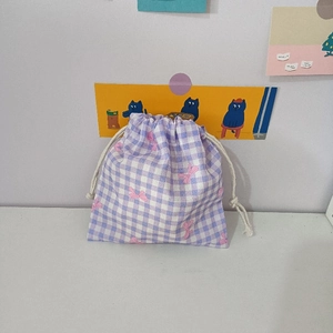 Detail of purple gingham drawstring pouch with pink bow prints and white cotton cords
