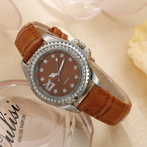 Gros plan d'une montre à quartz pour femme avec bracelet en cuir brun et lunette sertie