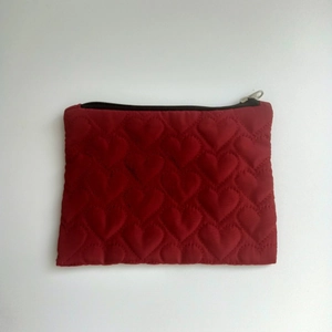 Makroaufnahme des roten Herz-Steppmusters und Reißverschlussdetails an der kleinen Tasche