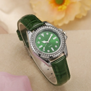 Detail of luxury green leather watch with rhinestone bezel and sunray dial