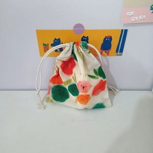 Detail of floral cotton drawstring pouch featuring cute cartoon flower patterns and dual ties