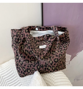 Détail du sac cabas rétro en peluche léopard avec fermoir magnétique et étiquette de marque