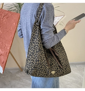 Detail of leopard print tote bag showing large capacity and stylish metal logo plate