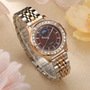 Macro detail of quartz watch with rose gold strap and diamond bezel on floral background