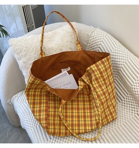 Macro shot of plaid canvas tote interior with orange lining and convenient storage pocket