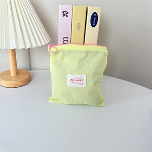 Detailed shot of yellow macaron cosmetic bag with pink zipper and Mayrabbit label