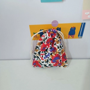 Close-up of floral cotton drawstring pouch with red and blue flowers and white woven rope
