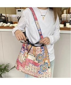 Close-up of ethnic patchwork denim bag with colorful floral patterns and wide strap