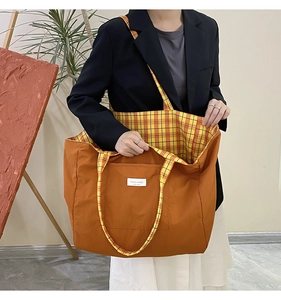 Detail of vintage orange canvas tote bag showing inner checkered lining and front pocket
