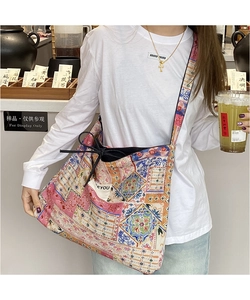 Detailed shot of ethnic patchwork denim bag with colorful patterns and adjustable strap